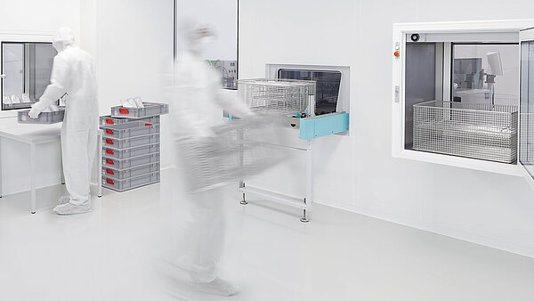 Reinigungssituation in einem Reinraum, im Hintergrund Transfersystem MAFAC Continuo