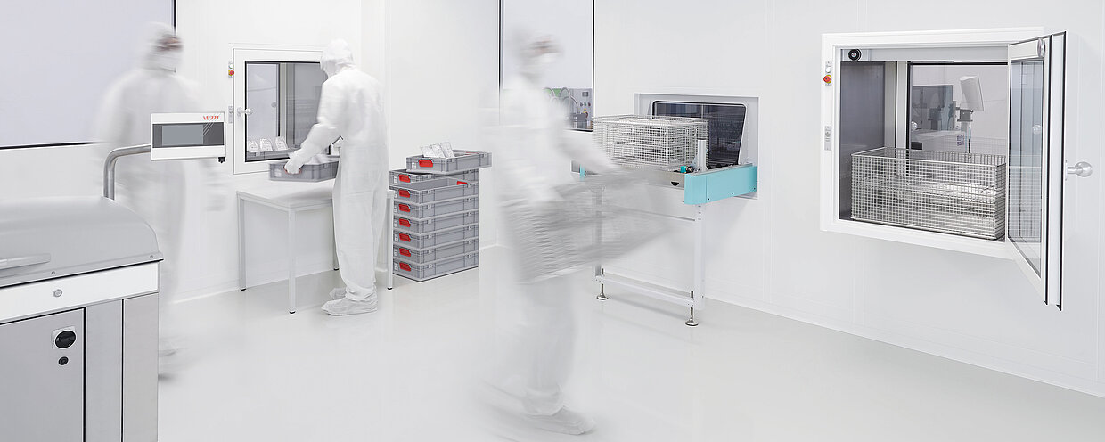 Reinigungssituation in einem Reinraum, im Hintergrund Transfersystem MAFAC Continuo