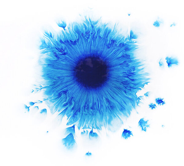 Ein zerfliessender, blauer Farbklecks auf Aquarellpapier 