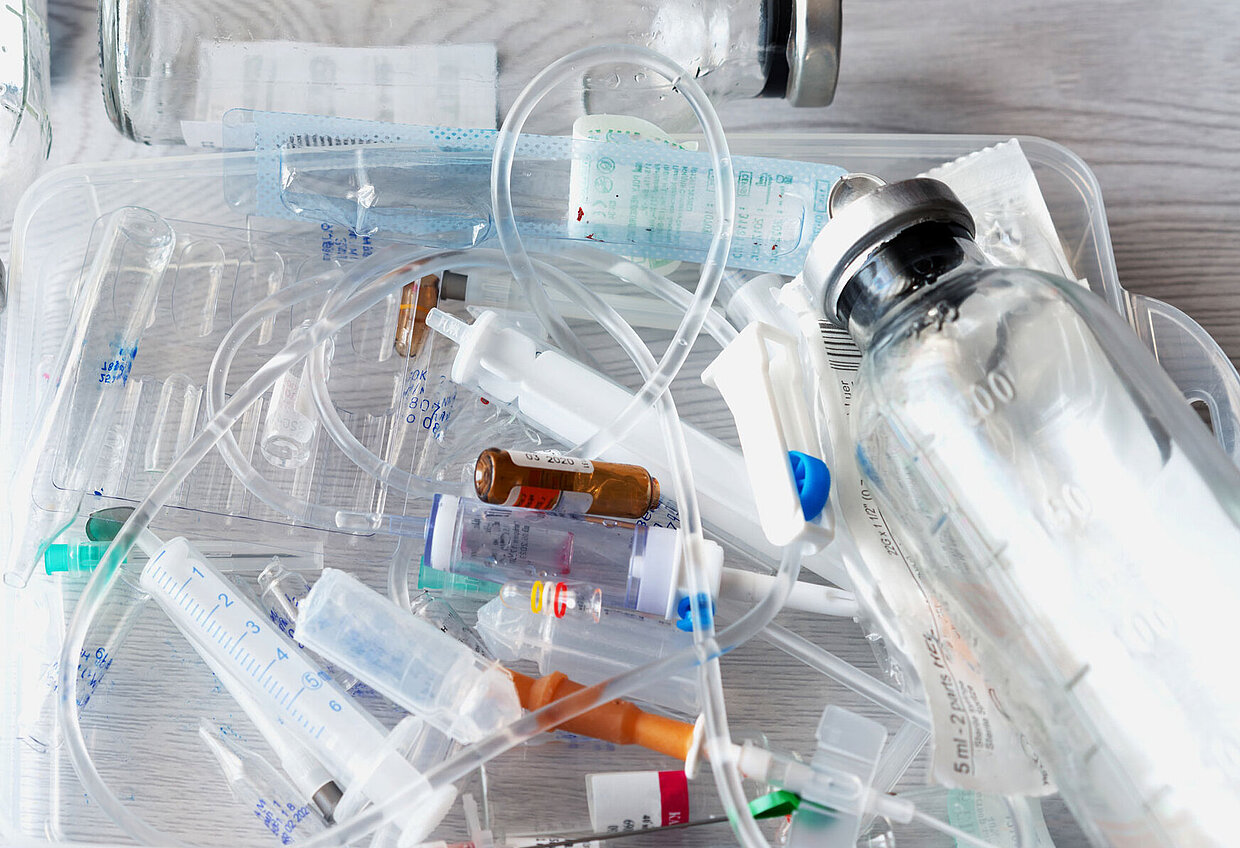 Blick auf medizinischen Abfall: Spritzen, Ampullen, Glasflaschen und Infusionsschläuche