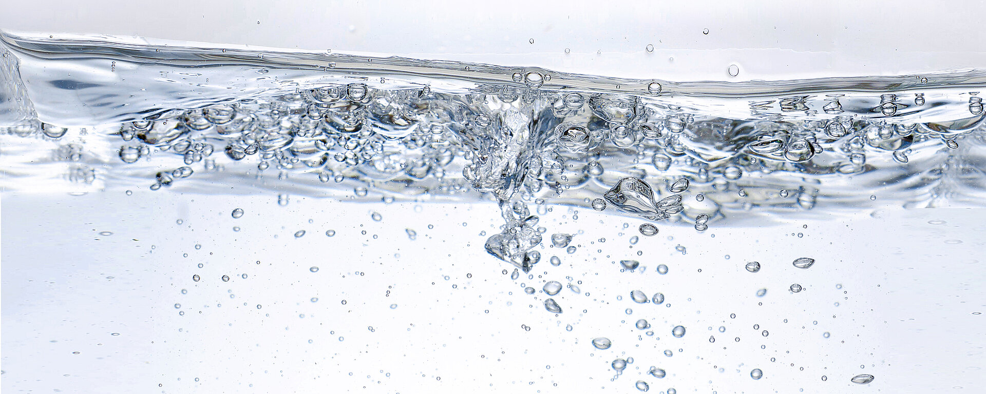 Nahaufnahme von sprudelndem Wasser mit vielen Luftblasen, die an die Oberfläche steigen.